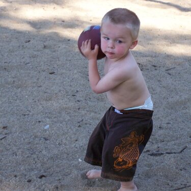 Nick playing football at the beach