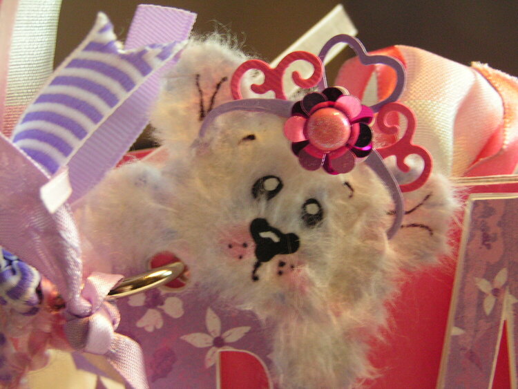 Close-up of peek-a-boo bear on front of album wearing flowered tiara
