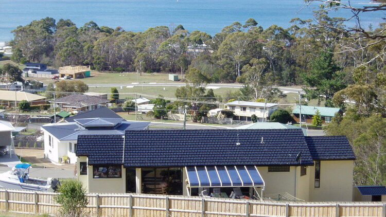 Back of our home. Clump of trees in front is the nature walk we go along to get to beach