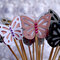 Butterfly shaped cupcake topper in soft pastel colors.