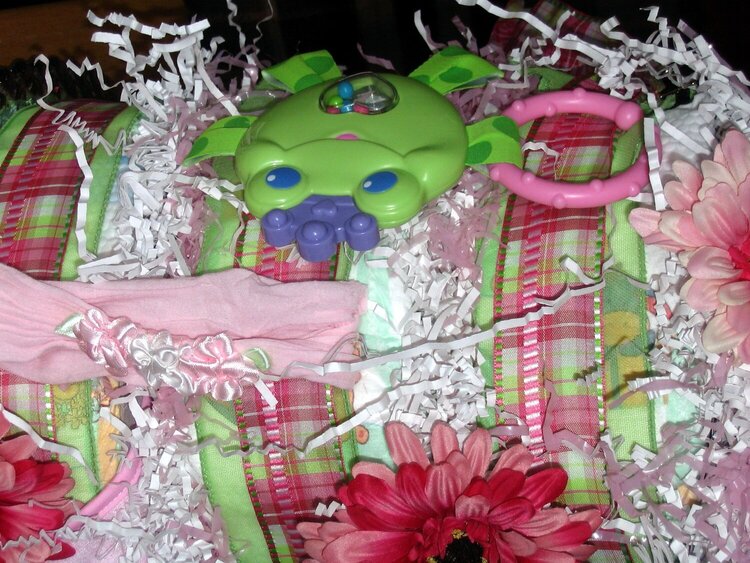 side of diaper cake a cute frog teether and pink headband