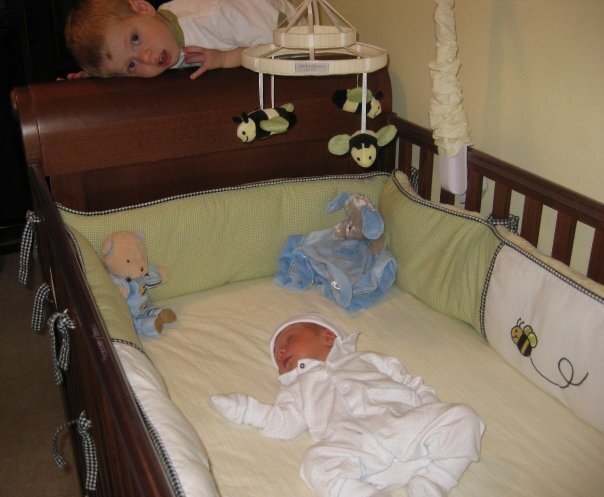 Luke peers down at baby Charlie