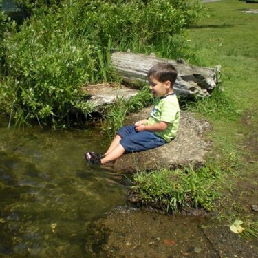Joseph sticking his feet in the lake