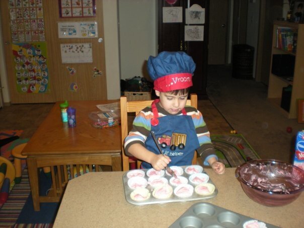 Joseph frosting the healthy cupcakes with good old fashioned sugary frosting! LOL!