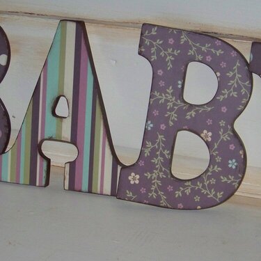 Brown and Pink Letters Spelling Baby