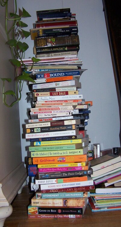 a pile of books that has been displaced from the shelf temporarily