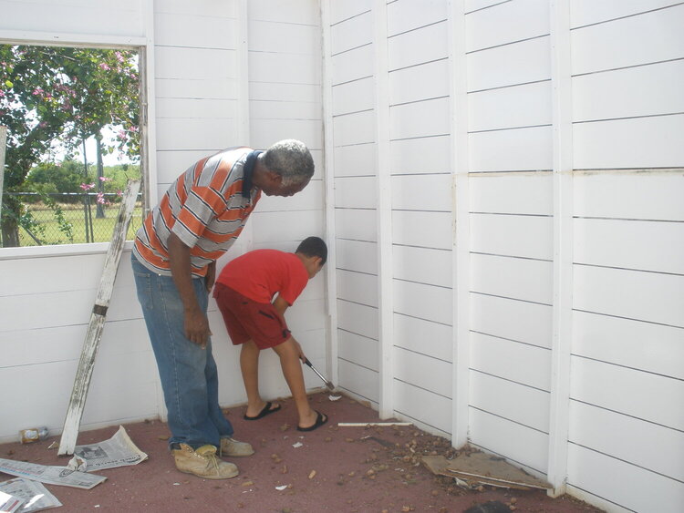My son helping the carpenter knock out the siding
